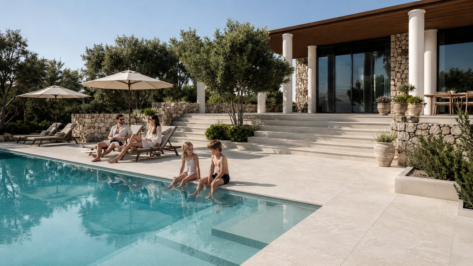 Warm travertine-look 20mm porcelain pavers on a sunlit Australian alfresco and pool surround, flowing from the interior floor.
