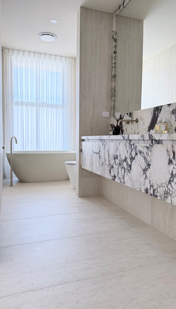 Atlas Concorde Marvel Travertine, a warm travertine and marble-look Italian porcelain in a sand tone.