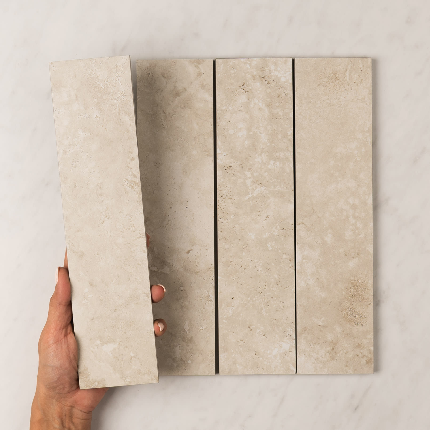 Precious travertine-look porcelain subway tile in a warm bianco tone, 75 by 300mm.