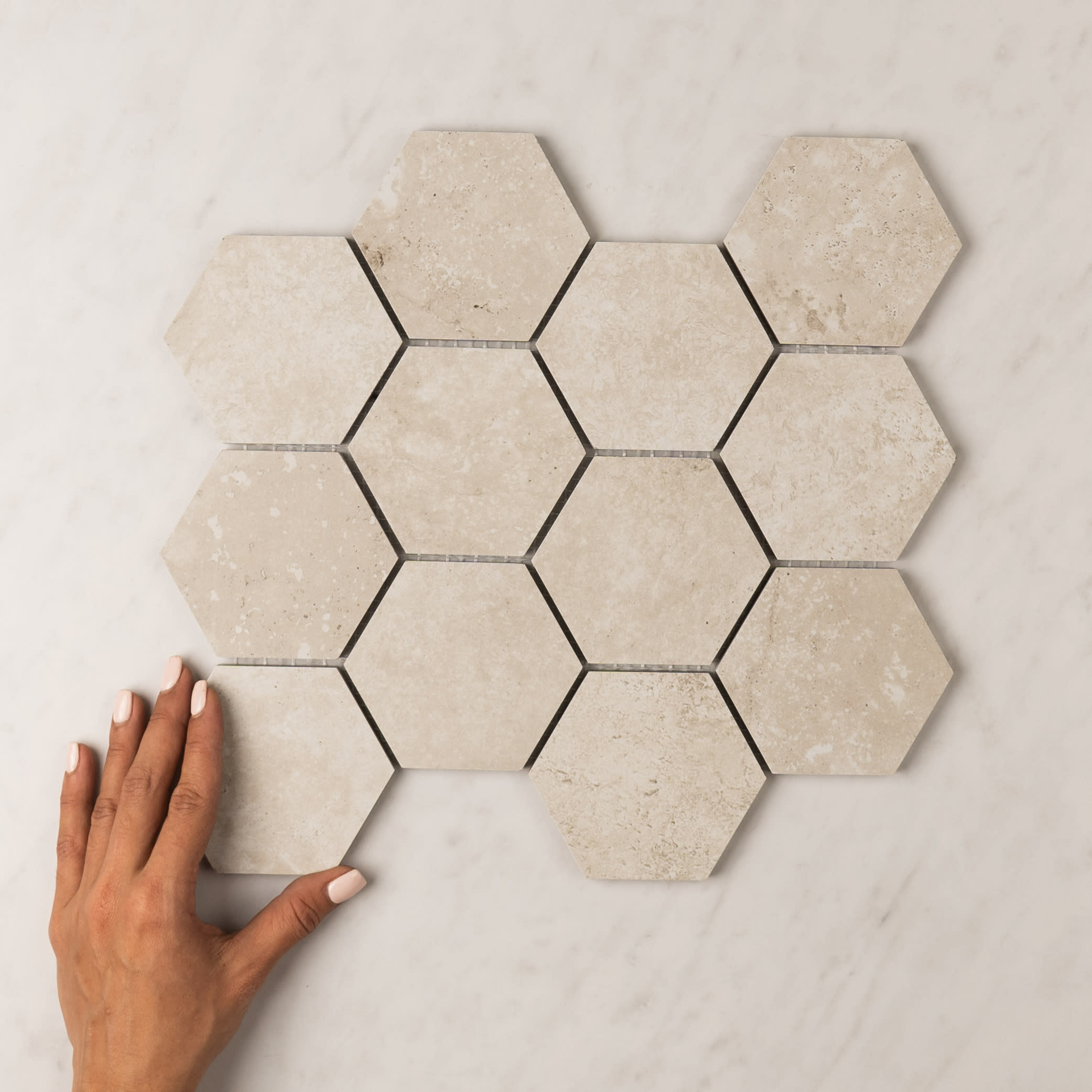 Precious travertine-look porcelain hexagon mosaic in a warm bianco tone.