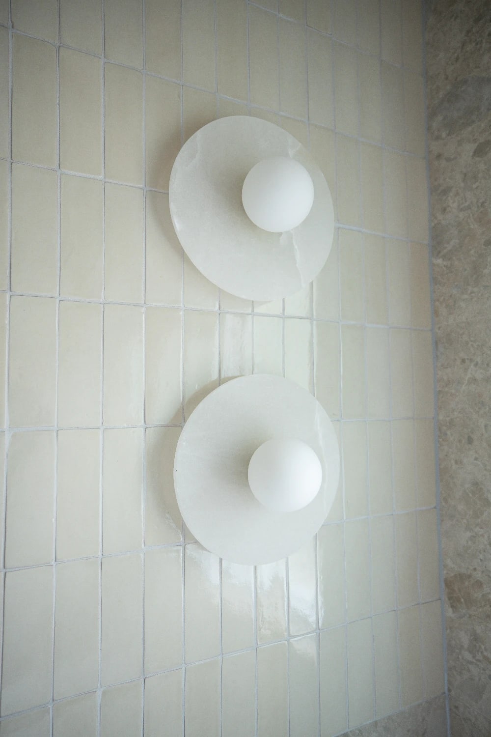 Marble wall sconces on the Zellige Natural feature wall - the glaze catching every flicker of light.