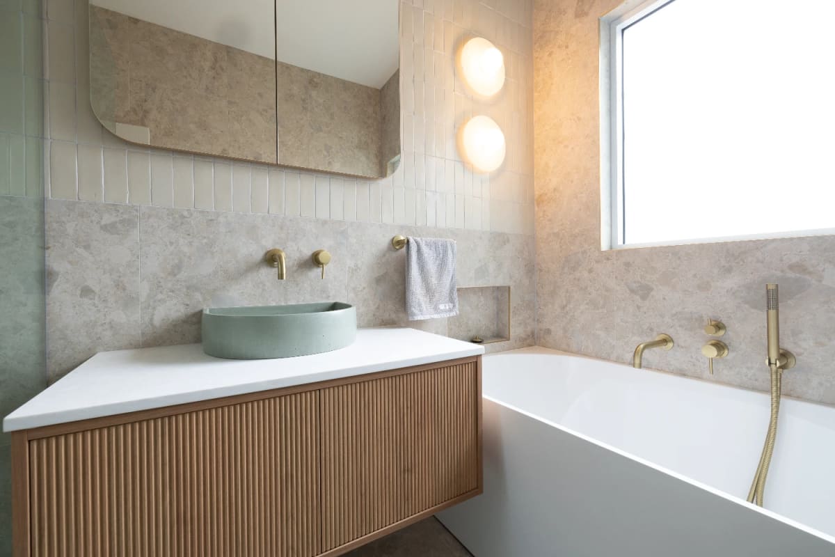 Main bathroom - Norrock Ivory porcelain with the Zellige Natural feature wall, mint basin on a fluted timber vanity, and brushed brass tapware throughout.