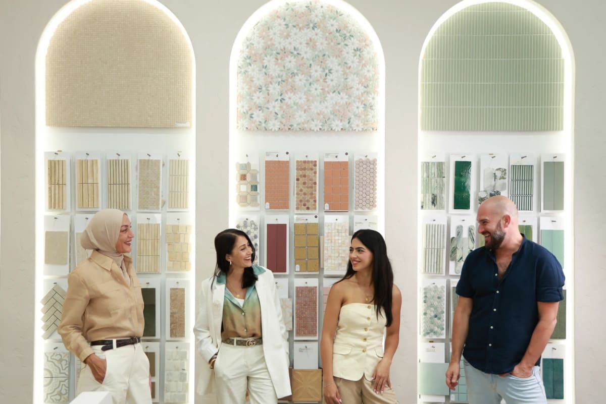 The Design Tiles design team in front of the Rockdale showroom's signature arched sample displays, backlit niches filled with curated tile paddles. The experienced Sydney team behind every free in-store terracotta consultation, in real showroom light.