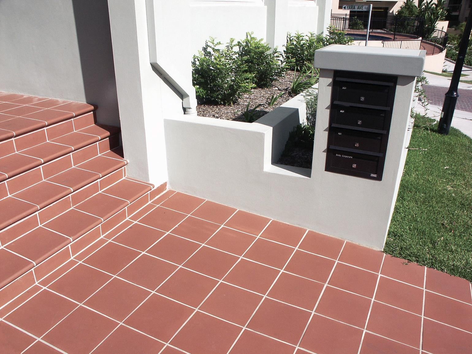 Alice Red real terracotta, subway, square and bullnose tiles laid in an outdoor floor area, authentic fired clay in a warm sun-baked red, presealed for alfresco use in a Sydney home.