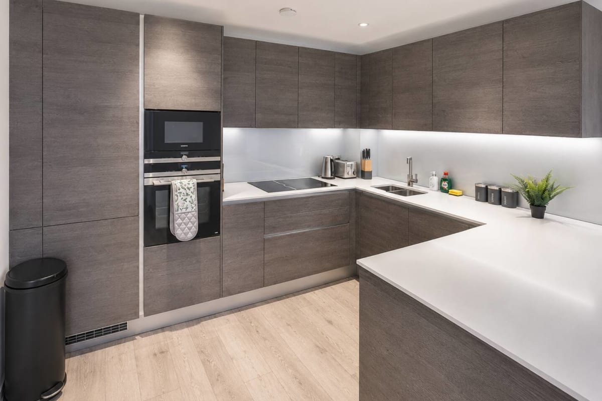 Kitchen with grey units and white worktops at the Camley Street apartment