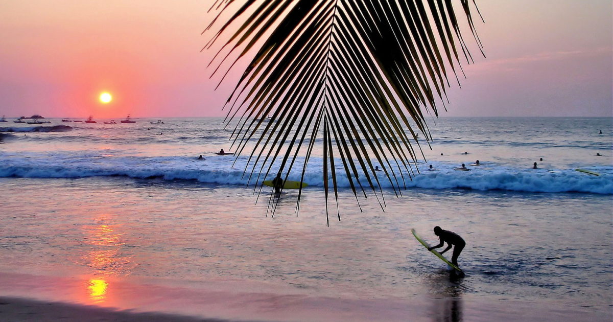 Surfers enjoying sunset at Tamarindo beach in Costa Rica
