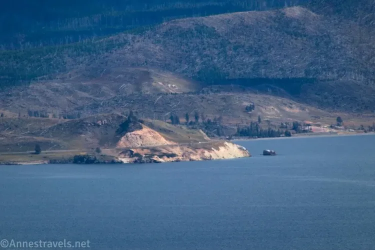A lake with a distant hillside in the sun and another in the shade