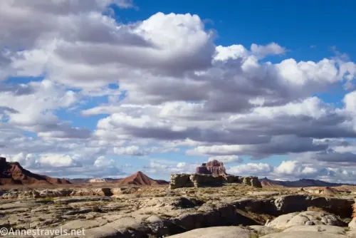 Clouds sail over the desert with distant rock formations and hills