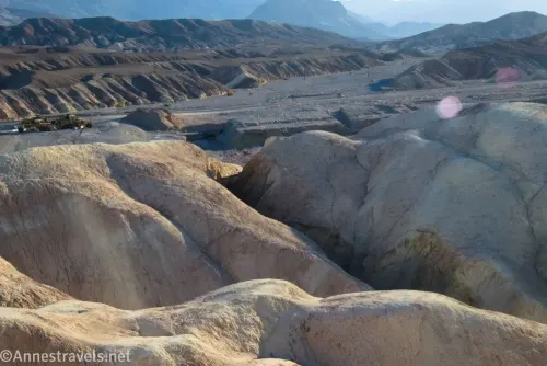 Badland hills in the foreground with a canyon through it and distant desert hills from Zabriskie Point in Death Valley National Park