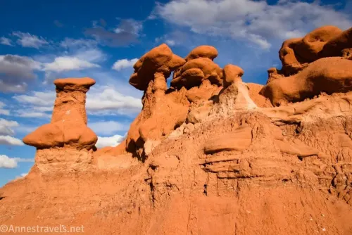 Hoodoo red rock formations against a blue sky with clouds