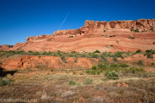 Striped rock cliffs across a grassy desert plain