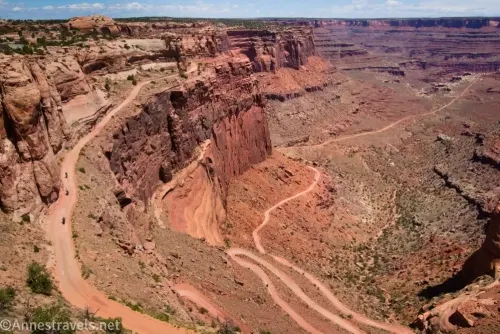 A dirt road wiggles up a desert canyon