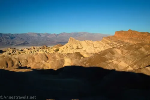 Morning light on Manly Beacon, striped badlands, and the Red Cathedral Canyon Crest from the Zabriskie Point Overlook in Death Valley National Park 