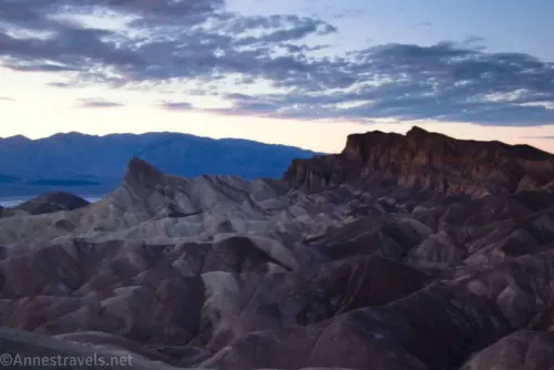 Sunset clouds and darkness settling over Manly Beacon and the Red Cathedral Canyon Crest from Zabriskie Point in Death Valley National Park 