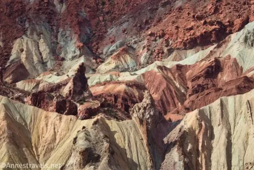 Yellow, red, and brown badlands below red rocks in Upheaval Dome