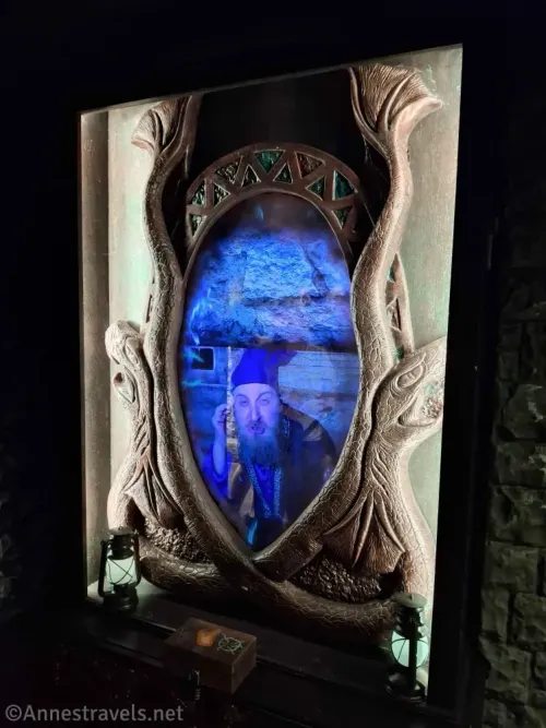 A "mirror" with a person in it bordered by snakes and with two lanterns in Nocturnal Keep Escape Room