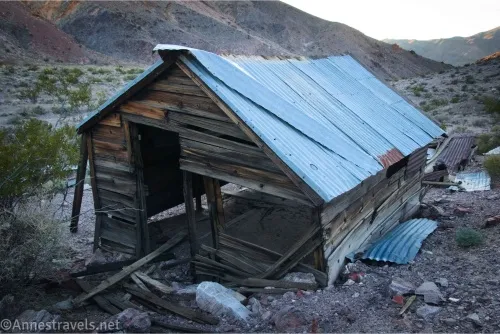 A falling-apart cabin with a metal roof in the desert 