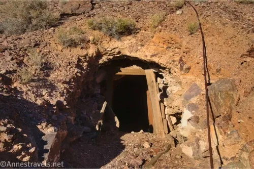 A mine shaft with wooden supports in a desert hillside