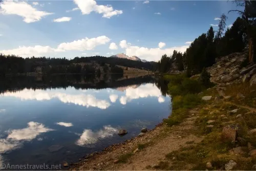 A lake reflecting clouds with mountains in the distance 