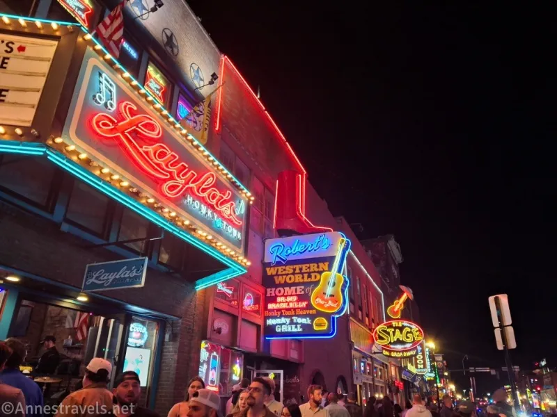 Signs for bars on Broadway, lit up with guitars 