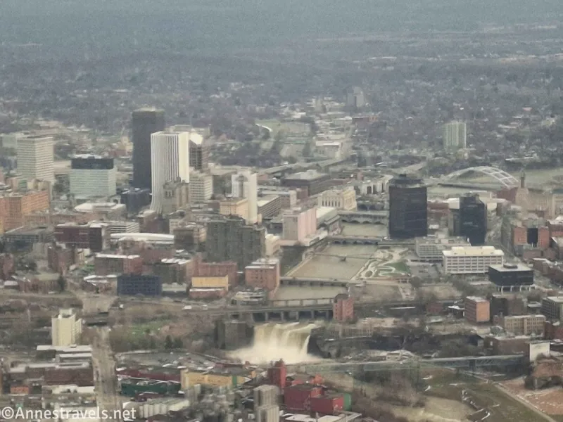A view of a city skyline with several bridges over a river and a large waterfall