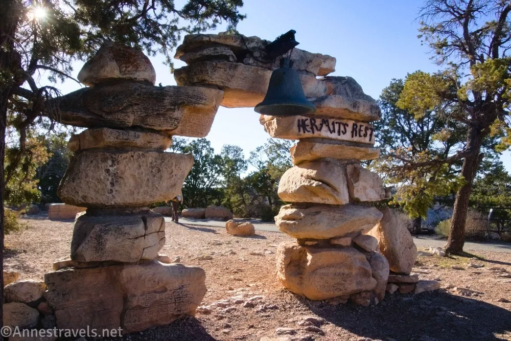 A stone archway with a bell and the words Hermits Rest