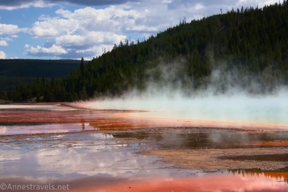 Steam clouds rise above the colorful Grand Prismatic Spring including reflections in the Midway Geyser Basin of Yellowstone National Park