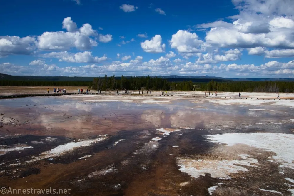 Clouds sail over the boardwalk and pools of the Midway Geyser Basin in Yellowstone National Park