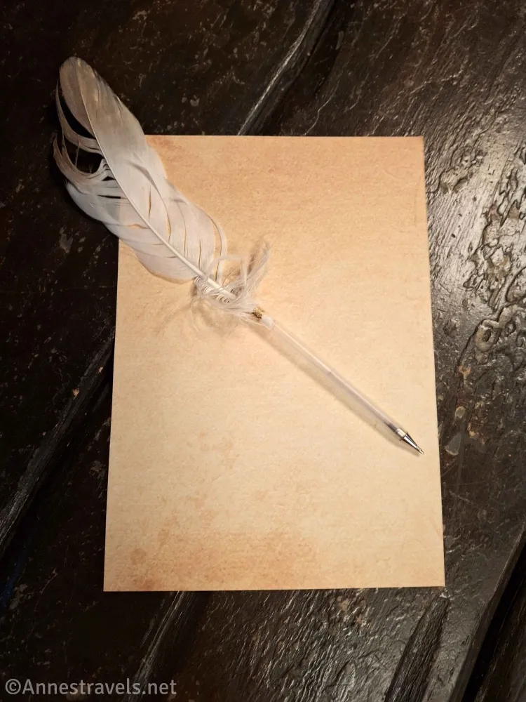 A pen with a feather and a paper