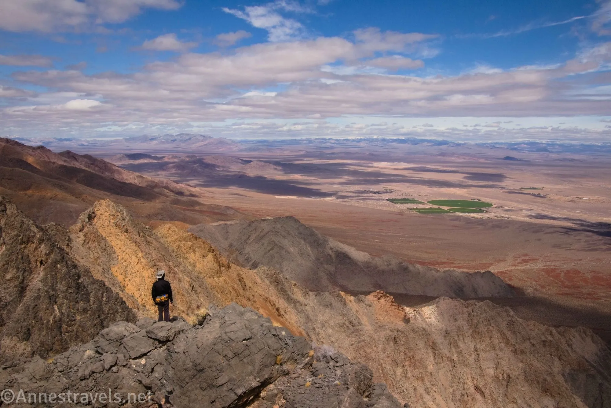 A hiker looking down on the Amargosa Valley from above the Echo Canyon Overlook in the Funeral Mountains of Death Valley National Park, California