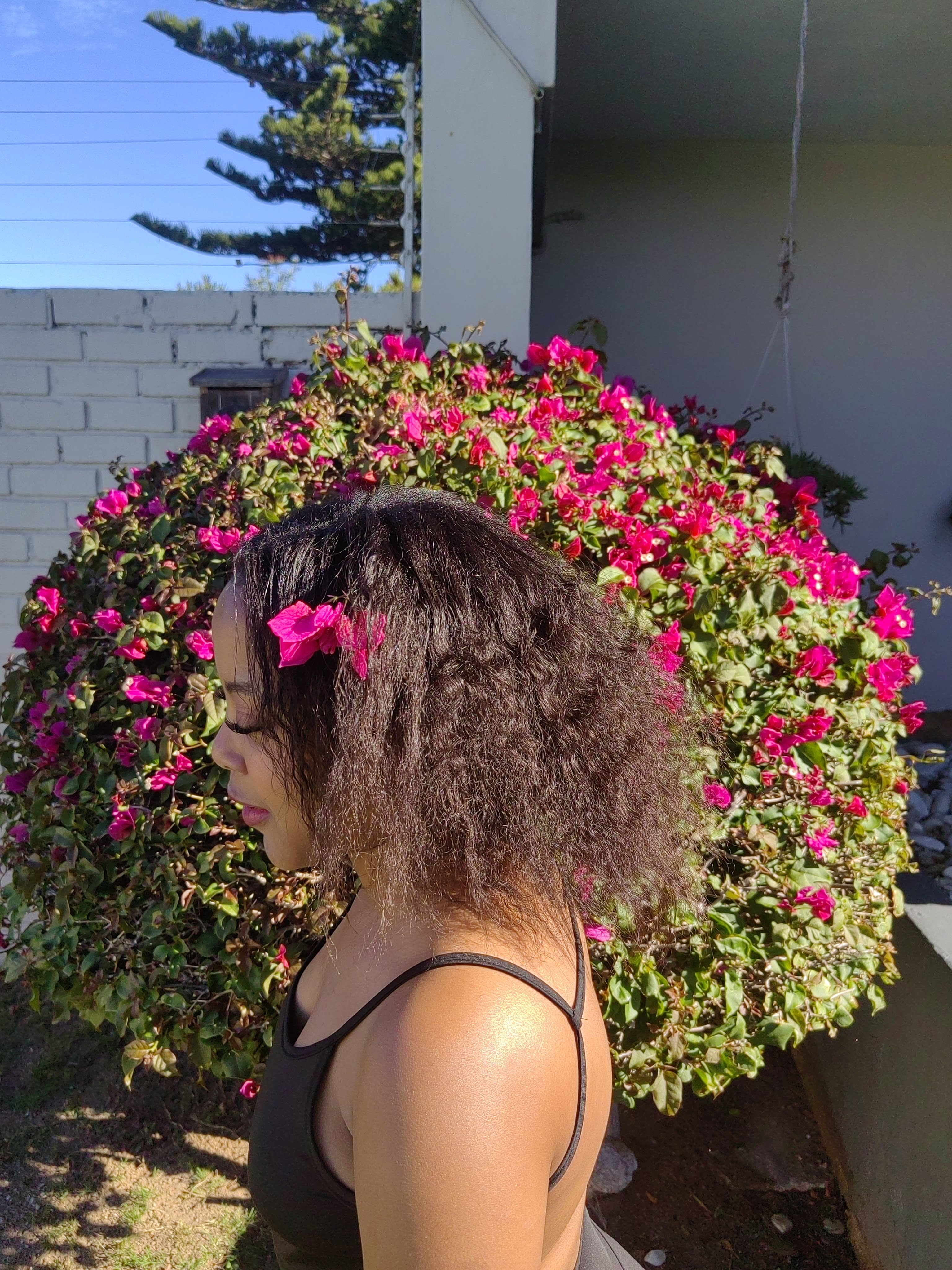 Profile with a pink bloom in the curls
