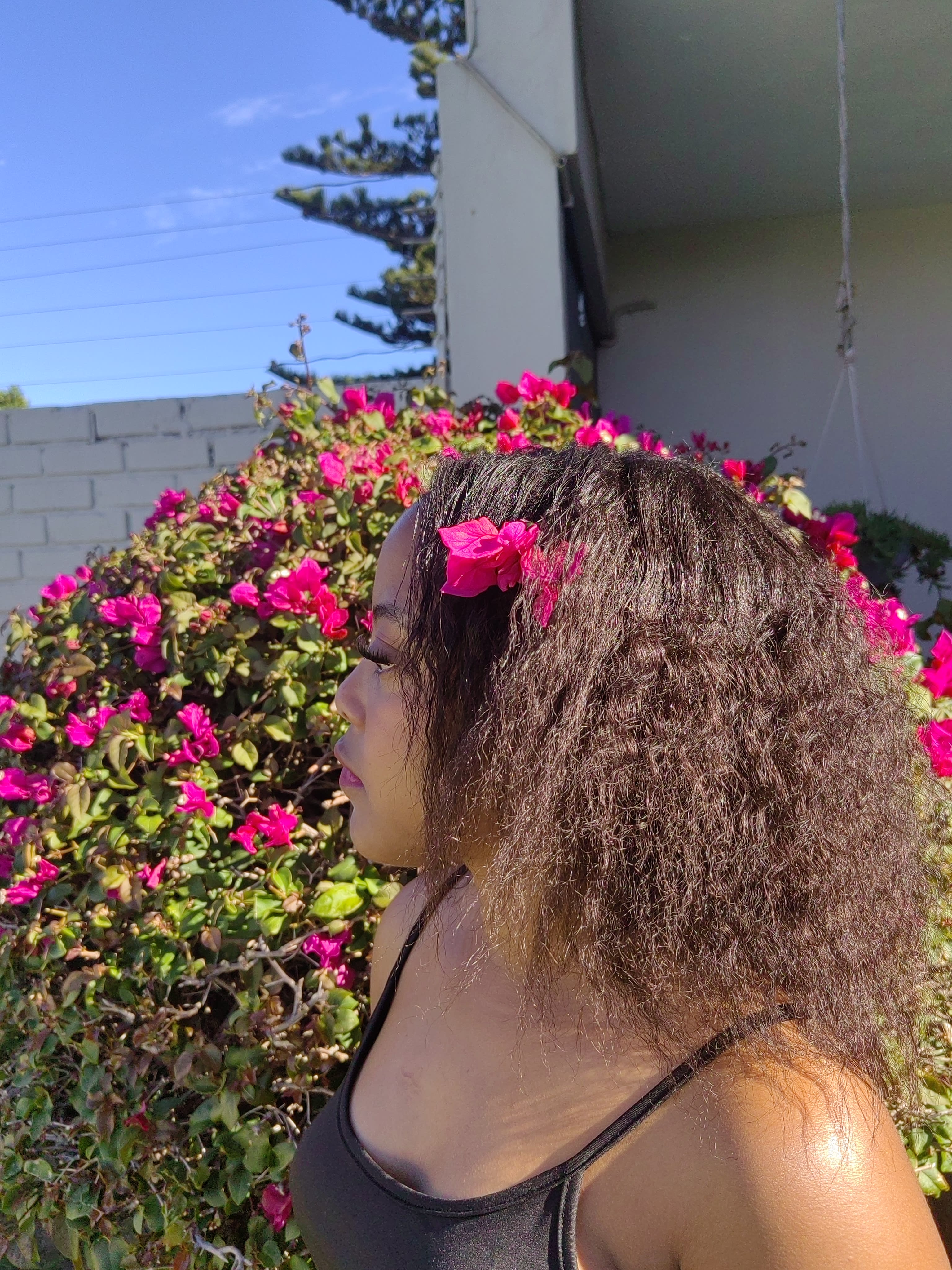Profile against a blue sky, flower in the hair