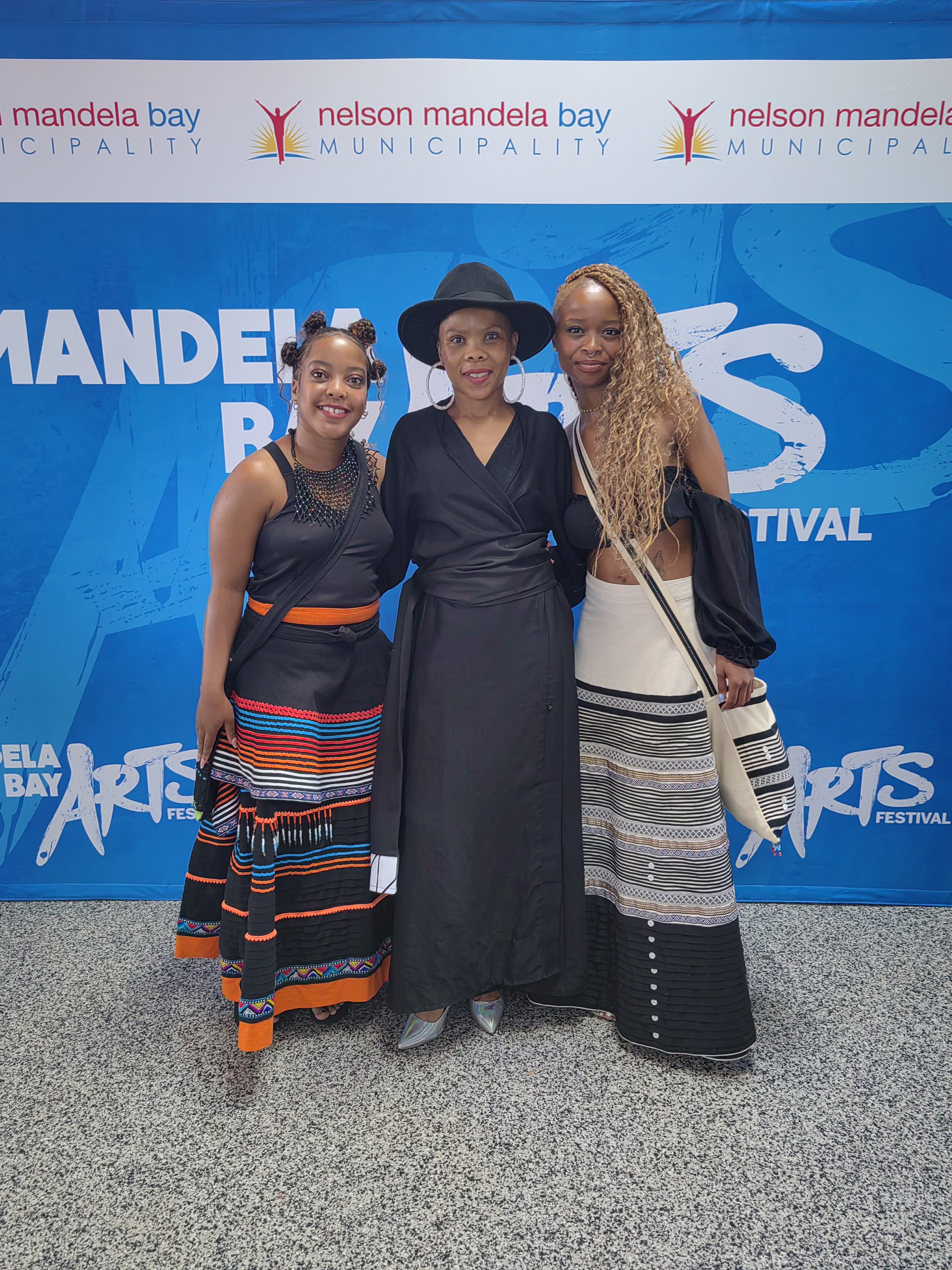 Three at the Mandela Bay Arts Festival backdrop