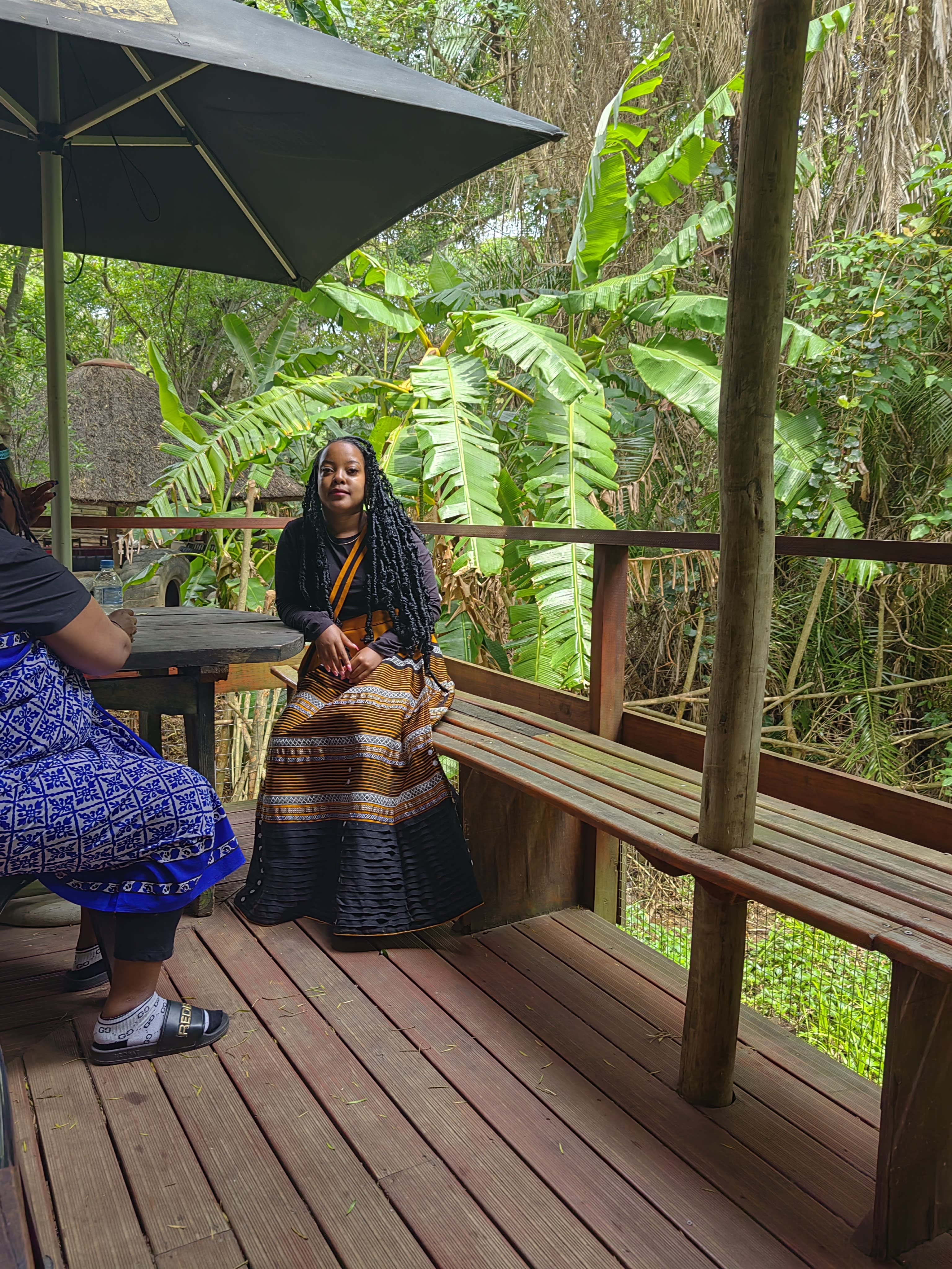 Laughing under an umbrella in gold-banded cloth