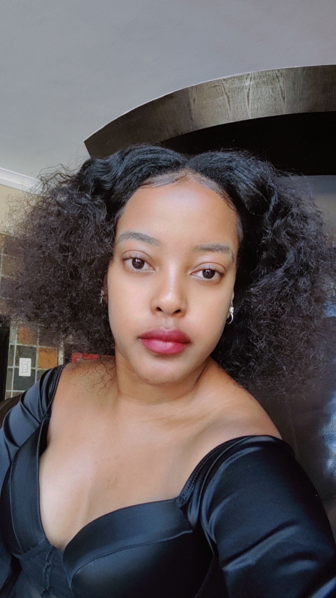 Black satin, a red lip, a direct gaze