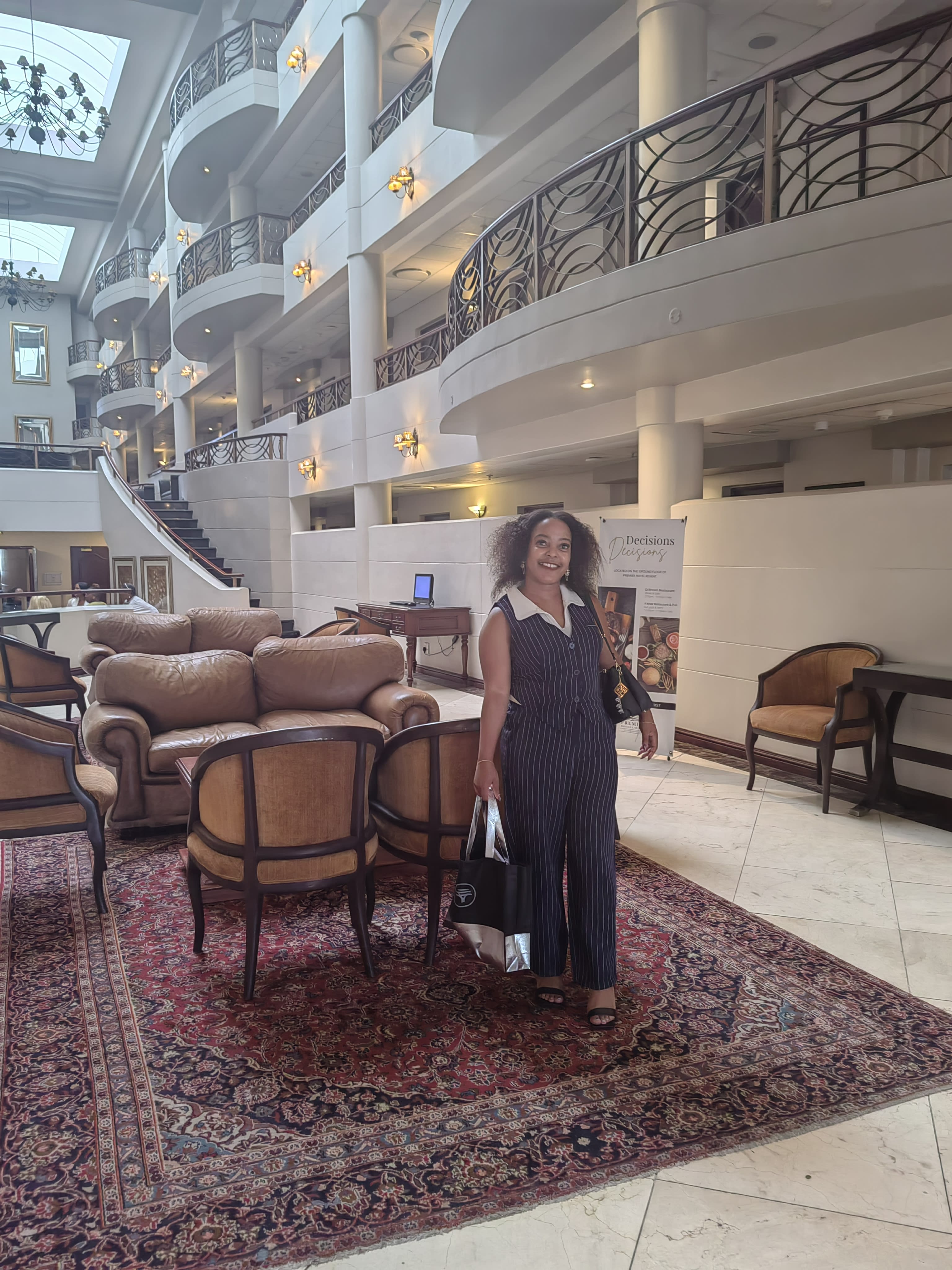 Working from a hotel lobby between other commitments, laptop bag in hand