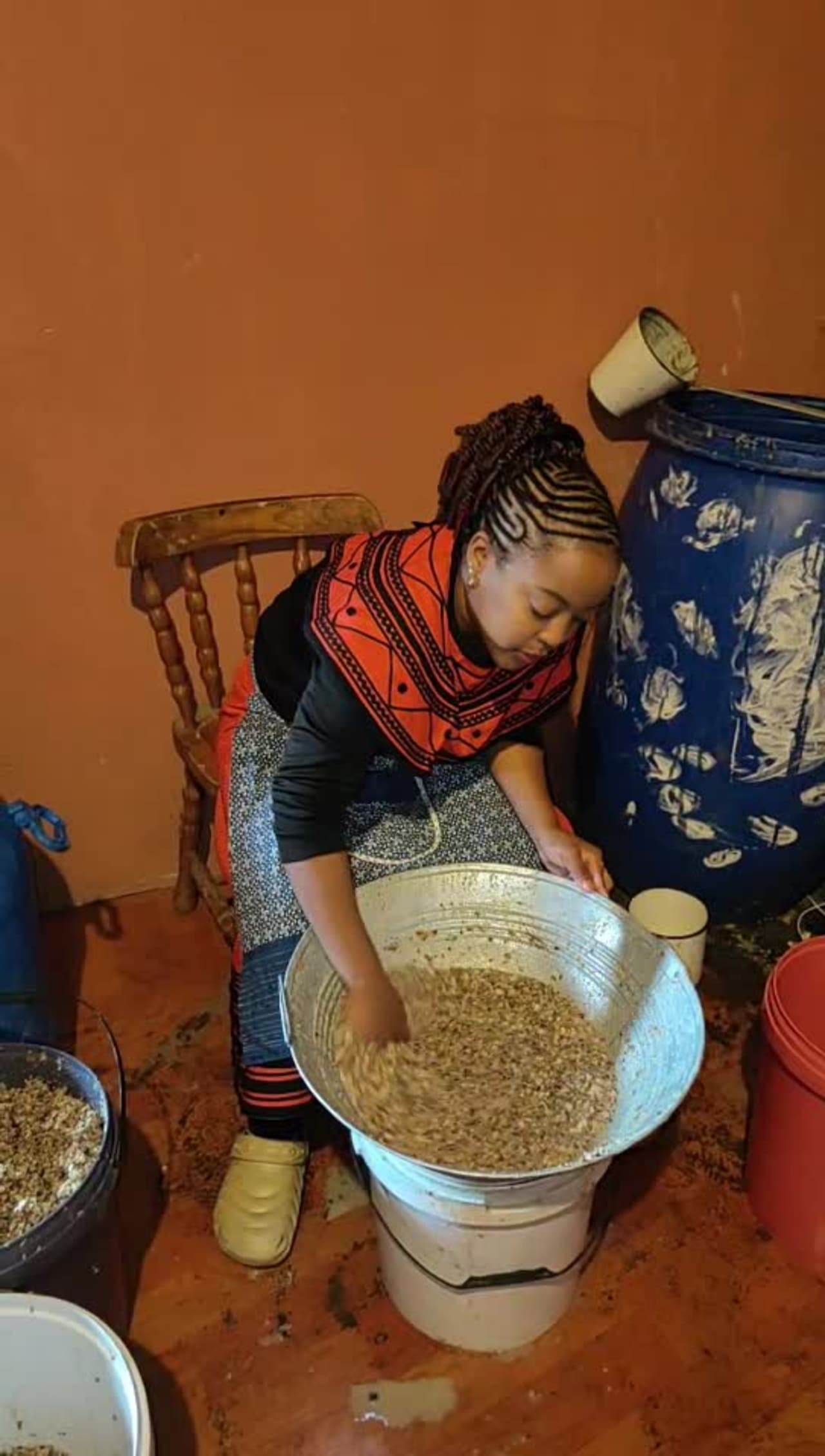 Nanda brewing traditional umqombothi in Xhosa beaded regalia