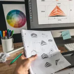 A man designing logos at his workspace.