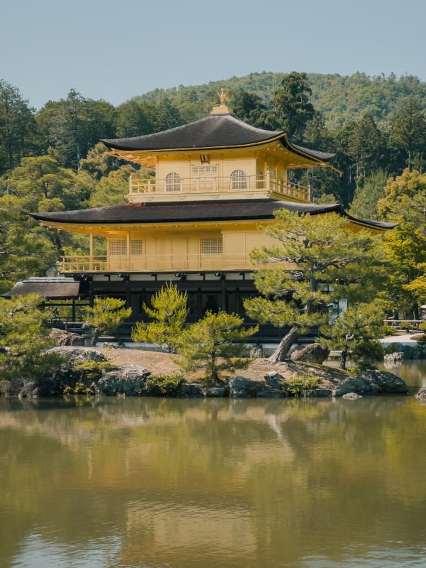Kinkaku-ji Golden Pavilion reflecting in Kyōko-chi pond, Kyoto, Japan. Lush Japanese garden, traditional temple architecture, phoenix statue.