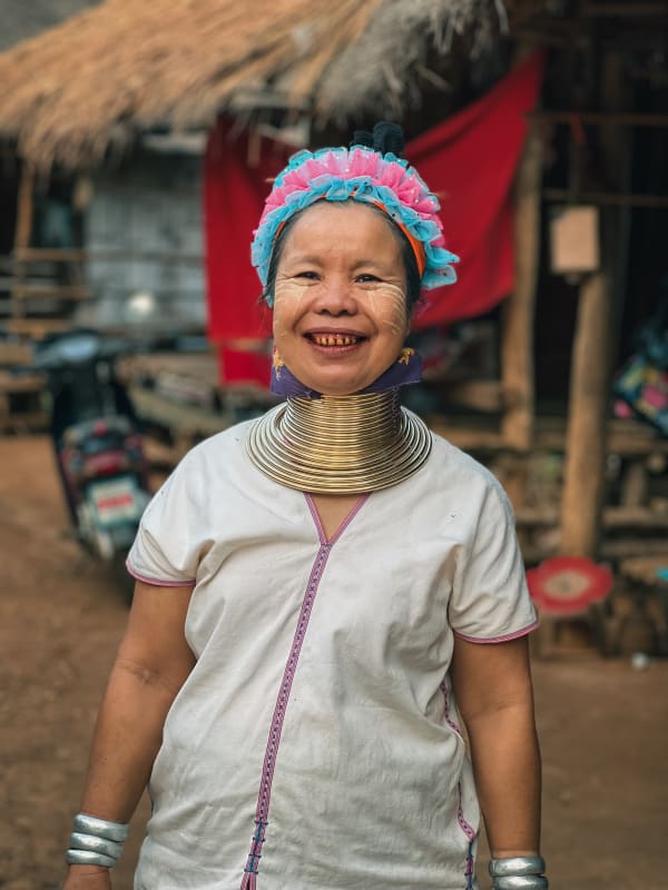 Portrait of smiling Kayan 'long-neck' woman from Chiang Rai, Thailand, with golden neck rings, silver bracelets.