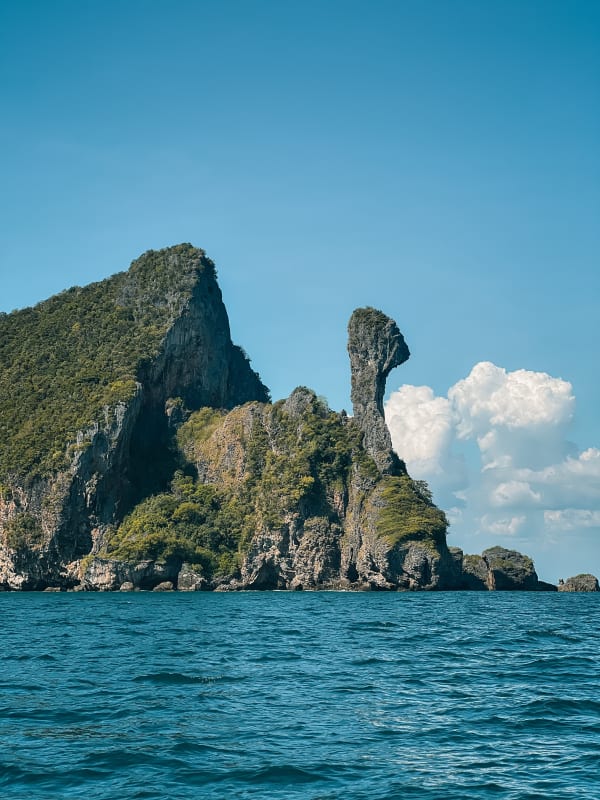 Chicken Island (Koh Kai), Krabi, Thailand. Limestone karst with lush tropical foliage, turquoise Andaman Sea, clear blue sky.