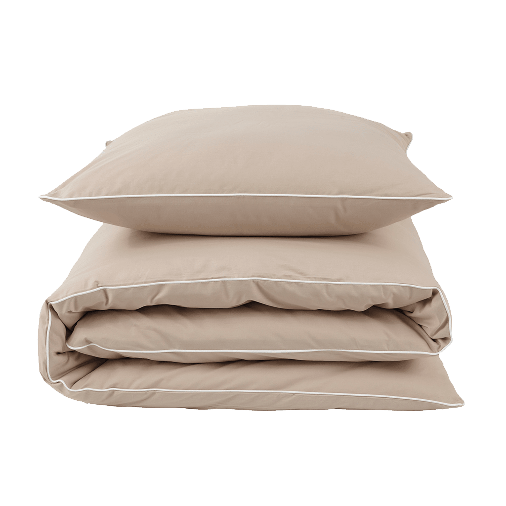 Beige sengetøjssæt: En pude ligger på en foldet dyne med hvid kant.