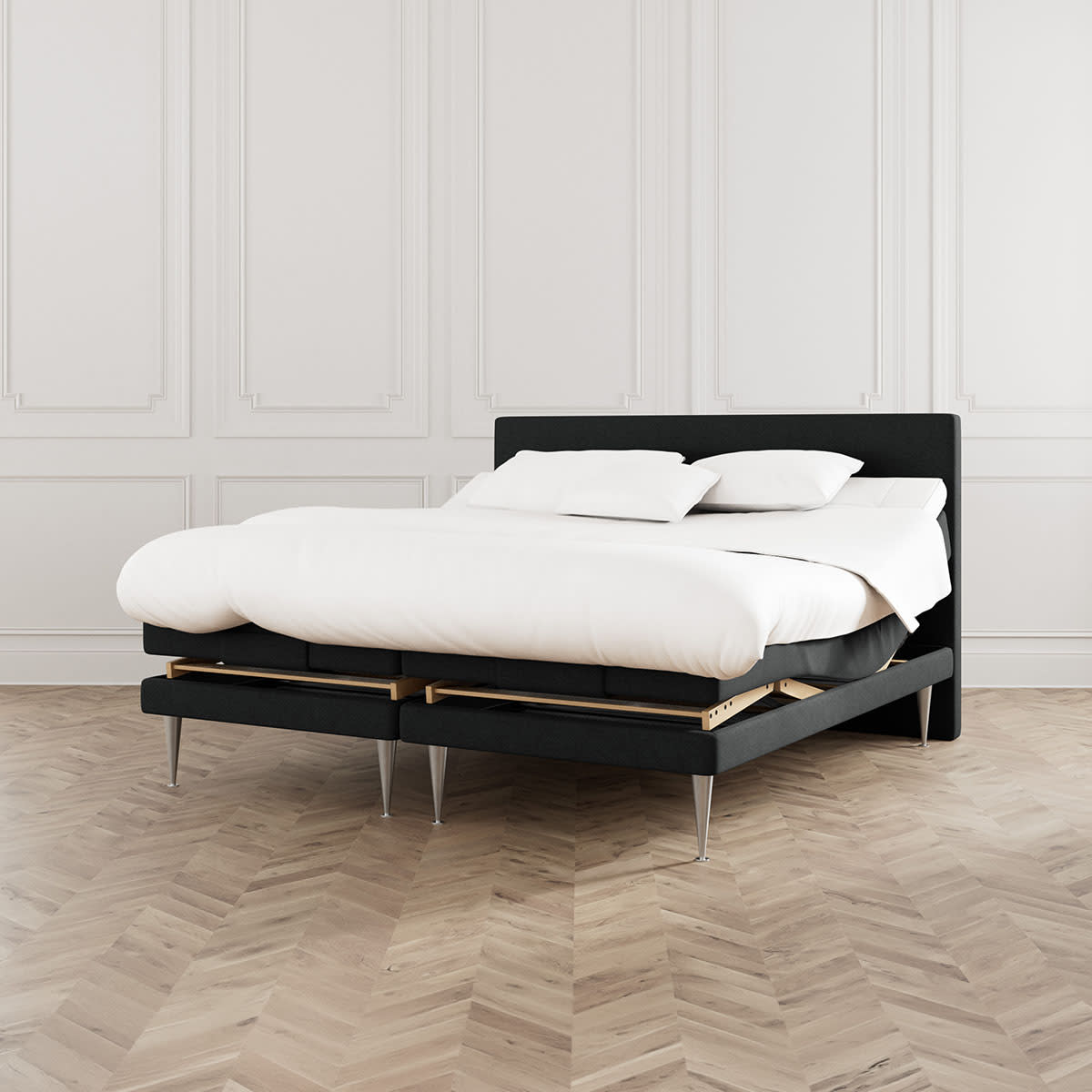 Sort elevationsseng fra MasterBed model Dozy med hvidt sengetøj og cocktailben, set forfra.