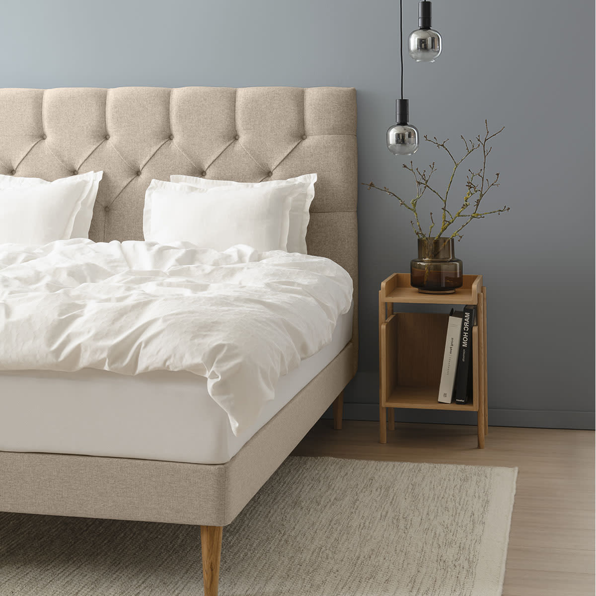 Beige seng fra TEMPUR Stay med stofbeklædt base og hvid madras, set fra siden.