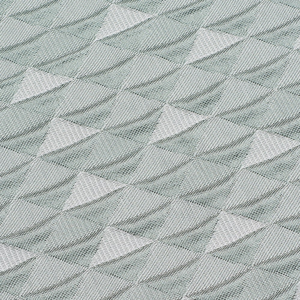 Tekstureret stof i lys grågrøn med et geometrisk mønster af skråtstillede romber, der skaber en 3D-effekt.