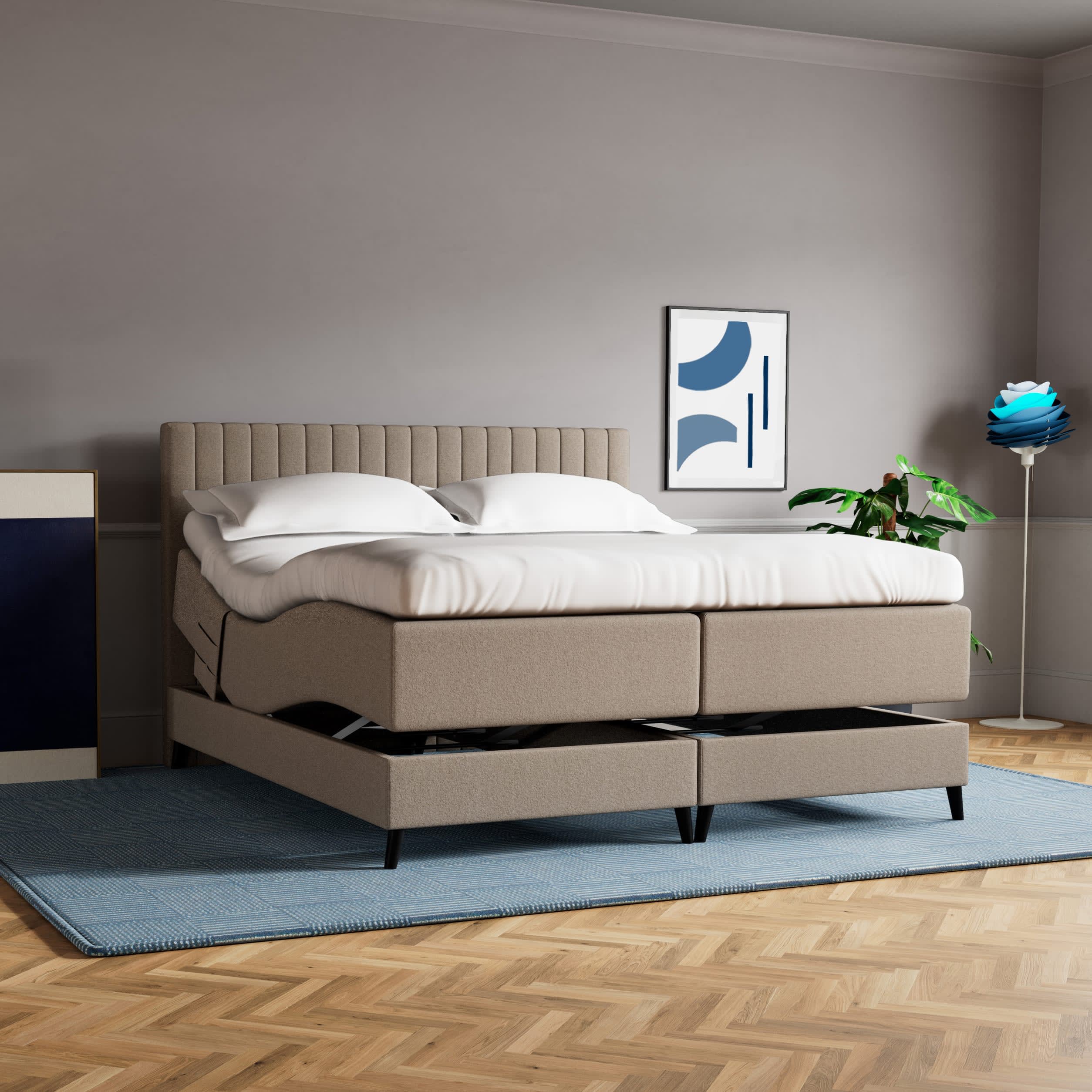 Beige elevationsseng med hvidt sengetøj i et moderne soveværelse. Sengen er hævet i begge ender.