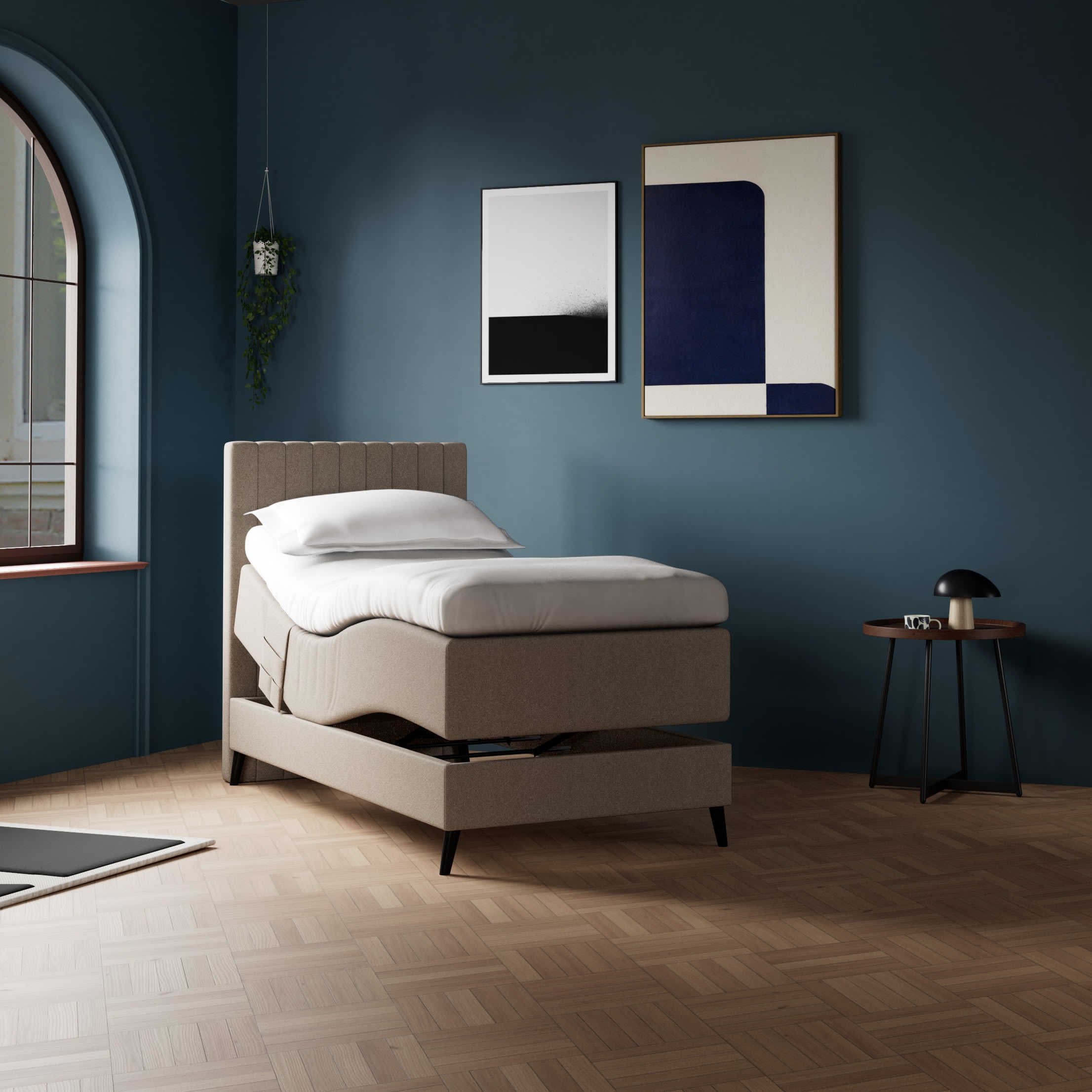 En moderne beige elevationsseng i et værelse med mørkeblå vægge, et buet vindue og trægulv. Kunsten hænger over sengen.