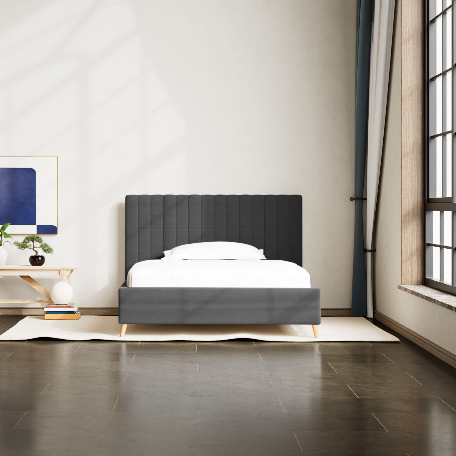 Moderne soveværelse med mørkegrå polstret seng, hvidt sengetøj og et stort vindue.