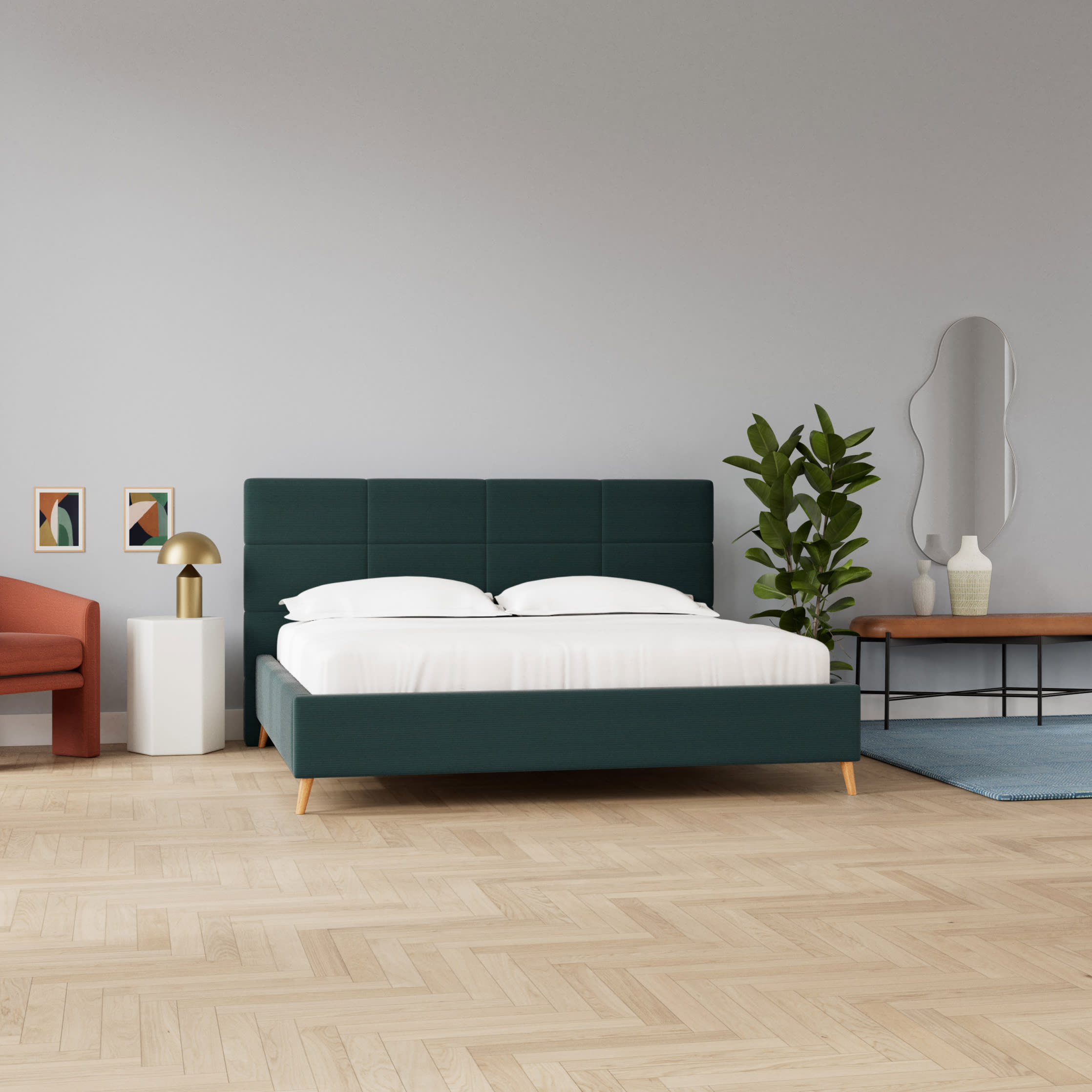 Et moderne soveværelse med en mørkegrøn seng, hvidt sengetøj og trægulv. En orange lænestol og en plante fuldender looket.