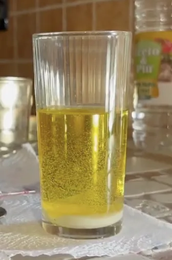 bicchiere pieno di olio con del bicarbonato sul fondo